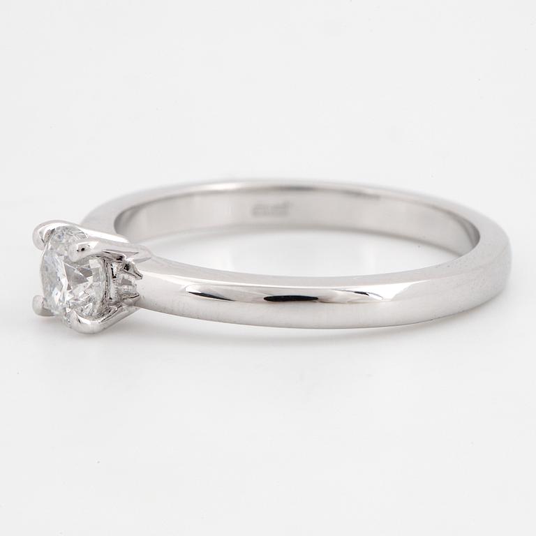 An 18K white gold ring set with a round brilliant-cut diamond.
