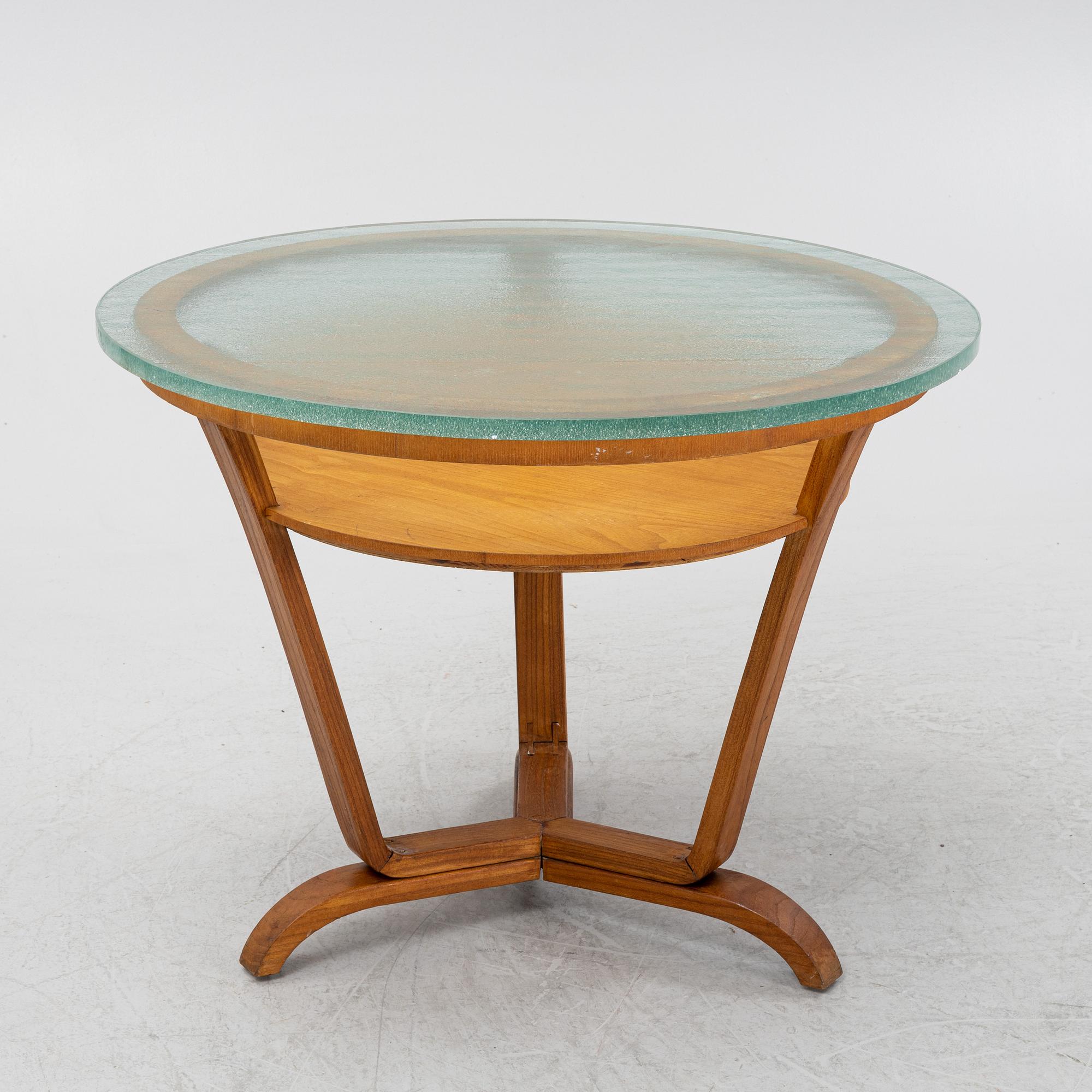 A Swedish Modern coffee table with a glass top. 1940's.