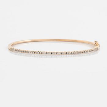 An 18K rose gold bangle set with round brilliant-cut diamonds.