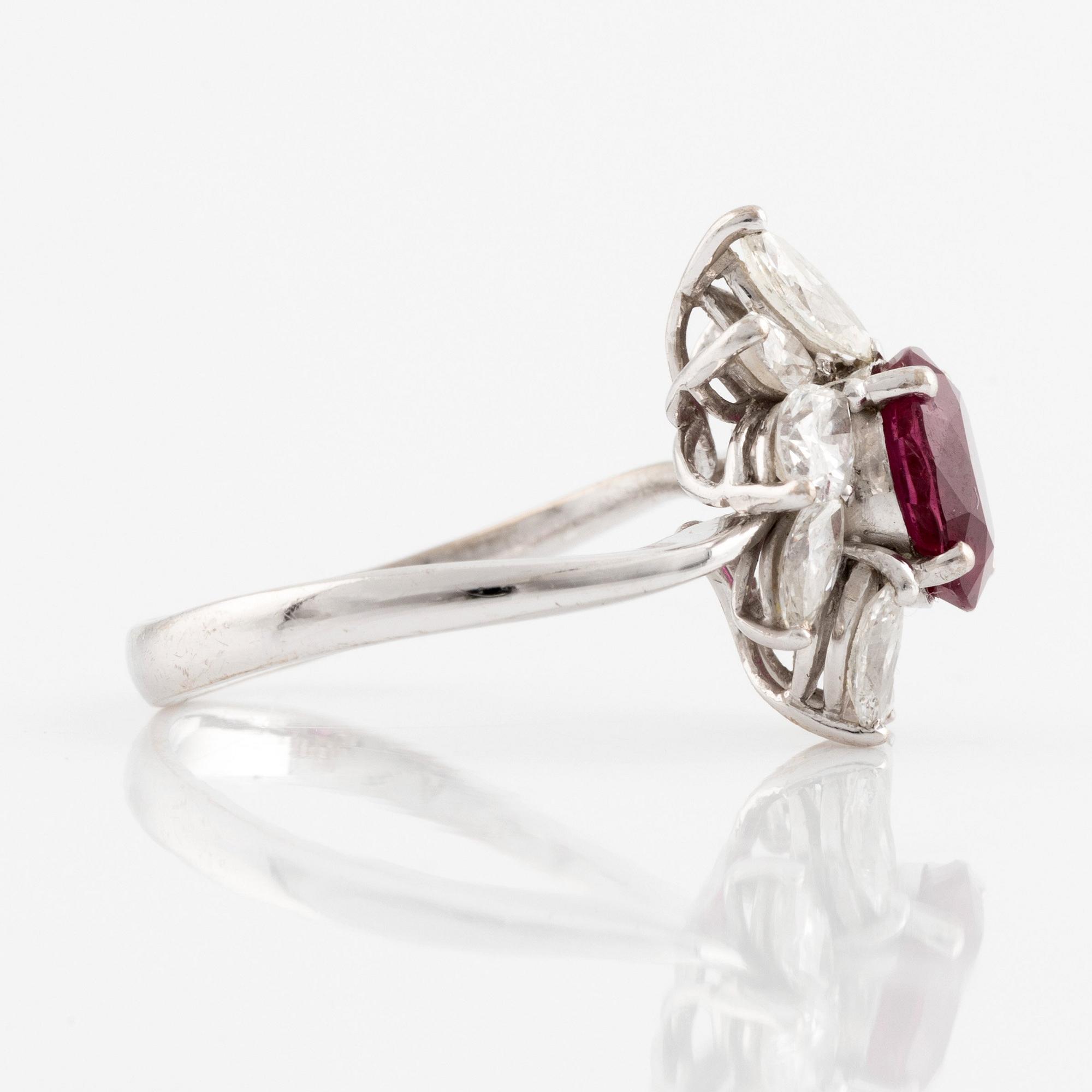 A ring set with a faceted ruby and navette-cut diamonds.