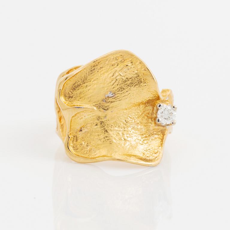 An 18K gold Ole Lynggaard ring set with a round brilliant-cut diamond.