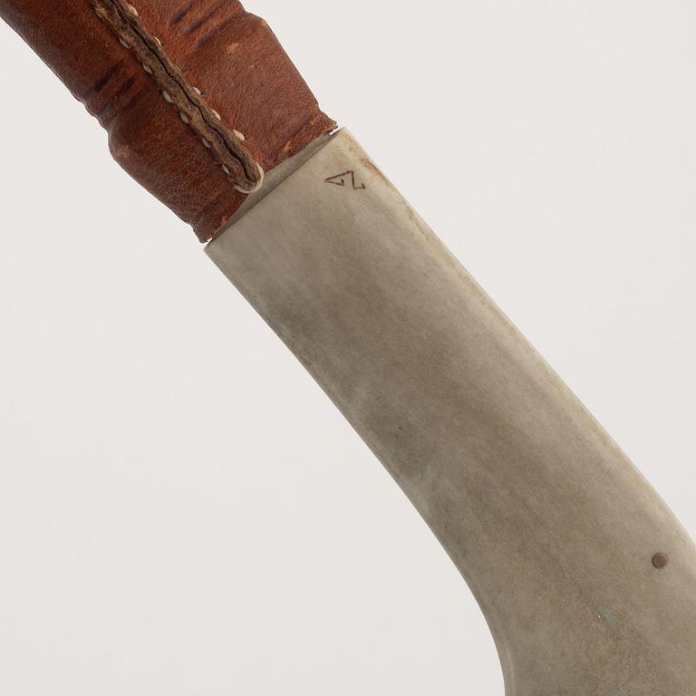A reindeer horn knife, signed.
