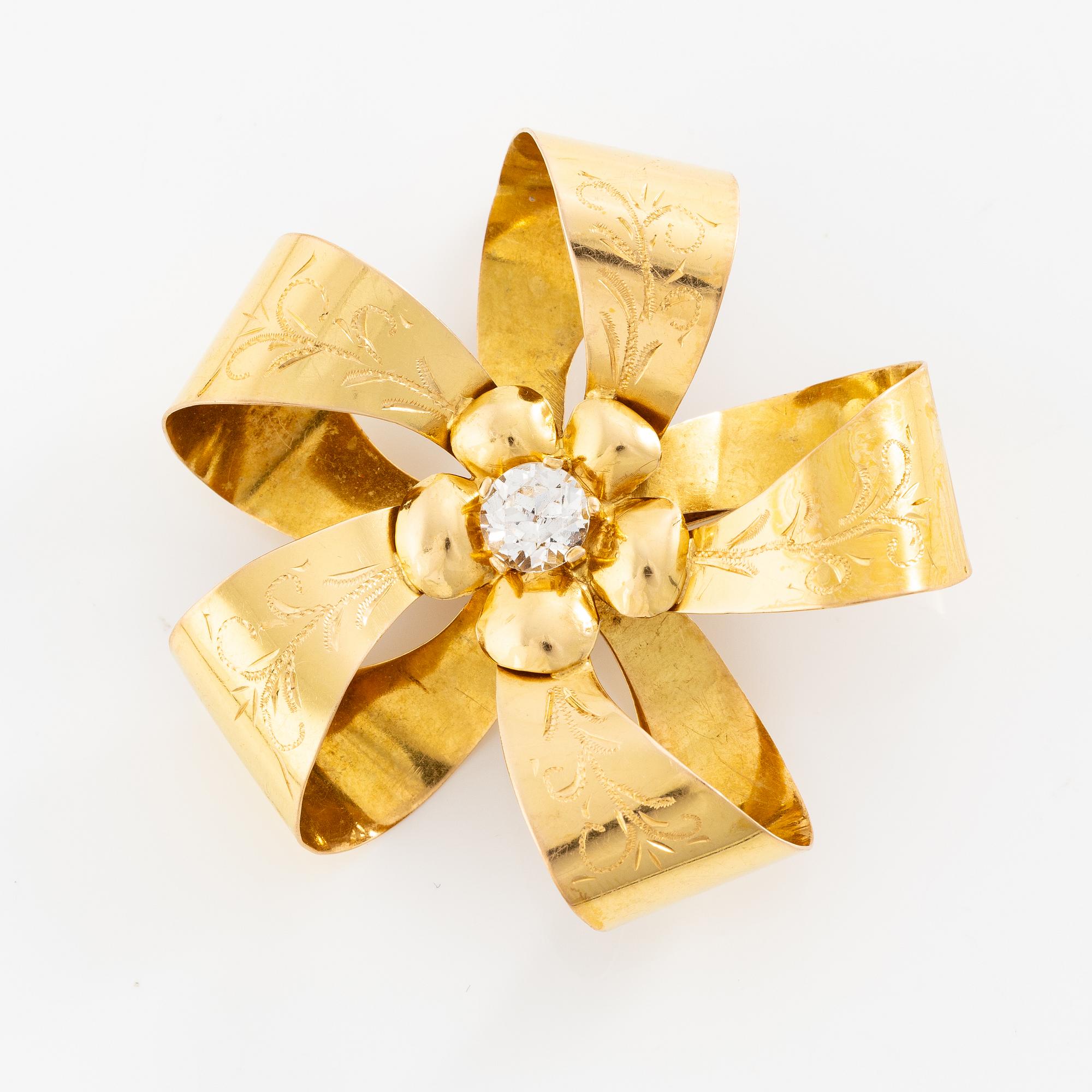 Brooch 18K gold with a white stone.