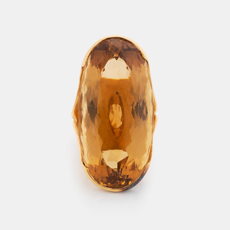 A Tina Karlsson ring in 18K gold set with an oval faceted citrine.