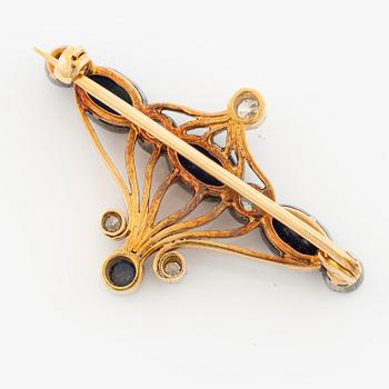 Brooch 18K gold and platinum set with step-cut sapphires and round brilliant-cut diamonds.