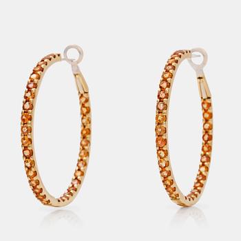 573. A pair of orange-yellow sapphire hoop earrings.