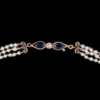 A PEARL NECKLACE, natural saltwater pearls. Clasp in 14K gold with sapphire and diamonds, Helsinki 1954.