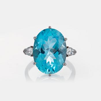 1047. An 18K white gold ring set with a faceted topaz and two pear shaped brilliant-cut diamonds.