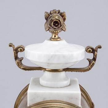 A French mantlepiece clock and a pair of candelabras, first half of the 20th century.