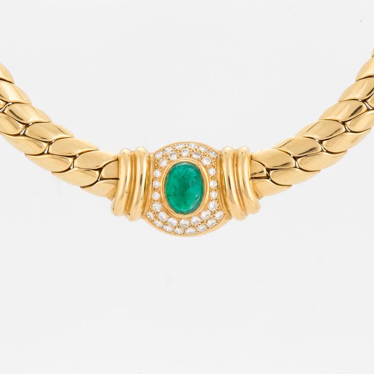 A necklace set with an oval, cabochon-cut emerald and round, brilliant-cut diamonds.