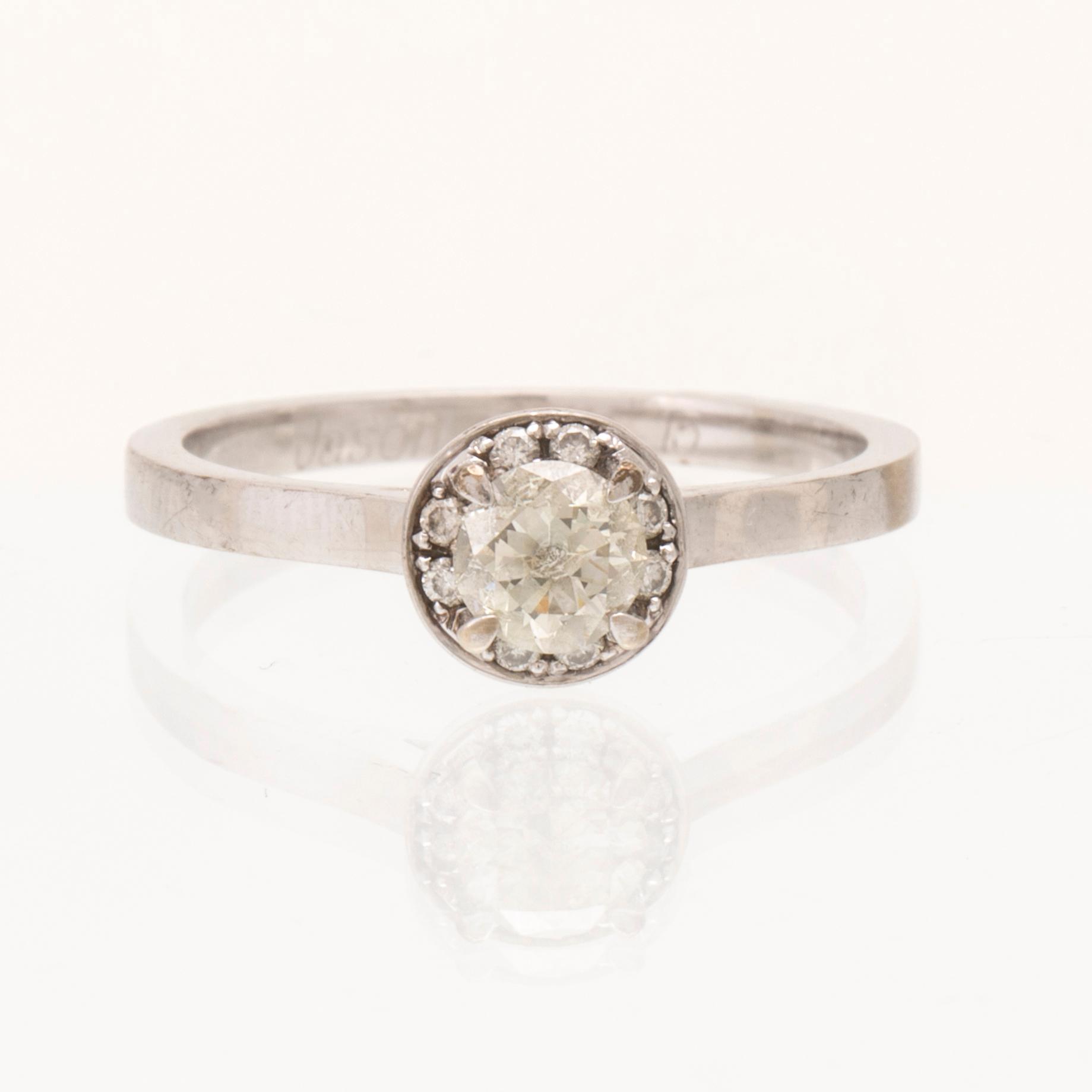 An 18K white gold ring set with round brilliant-cut diamonds.