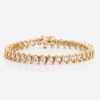 A 14K gold tennis bracelet, with brilliant-cut diamonds.