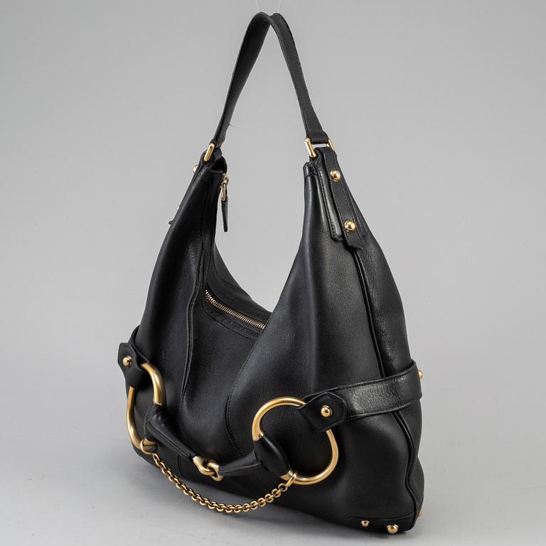 GUCCI, a leather horse-bit bag.