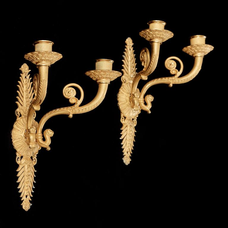 A pair of Empire early 19th century gilt bronze two-light wall-lights.