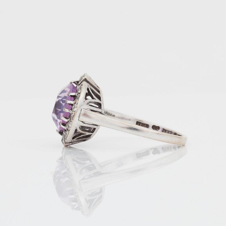 A circa 5.80 ct oval-cut pink sapphire and old-cut diamond ring. Total carat weight of diamonds circa 0.50 ct.