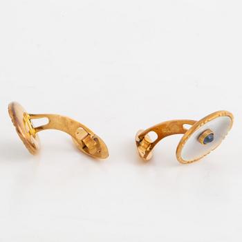 18K gold cufflinks with mother of pearl and cabochon-cut sapphire.