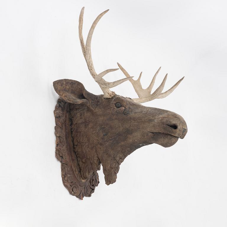 A wooden moose head with horns.