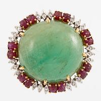 Brooch with a large cabochon-cut emerald, carved rubies, and octagonal-cut diamonds.