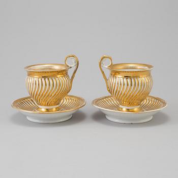 a pair of late empire porcelain cups with saucers from the first half of the 19th century.