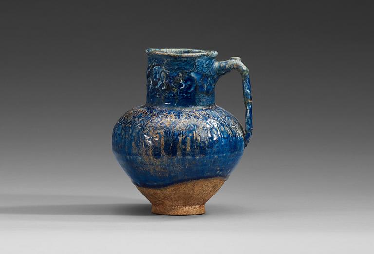 KANNA, lergods med blå glasyr. Höjd 18,5 cm. Persien (Iran) 1100-1200-tal, möjligen Rayy.
