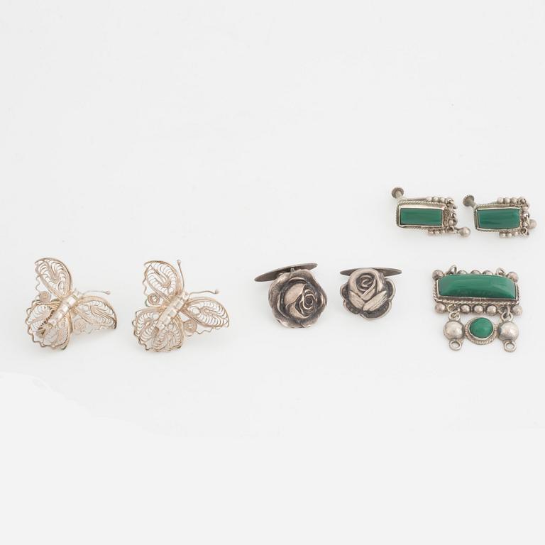 A silver belt buckle, three bracelets, two pairs of earrings, a pair of cuff-links and a brooch.