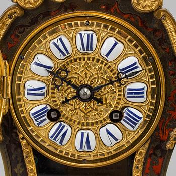 A Louis XV-style mantle clock with console base.