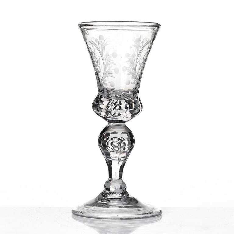 A cut and engraved glass goblet, dated 1755.