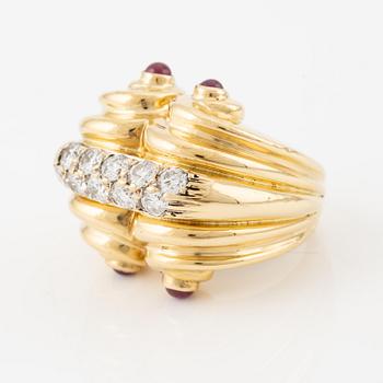 An 18K gold ring set with round brilliant-cut diamonds and cabochon-cut rubies.