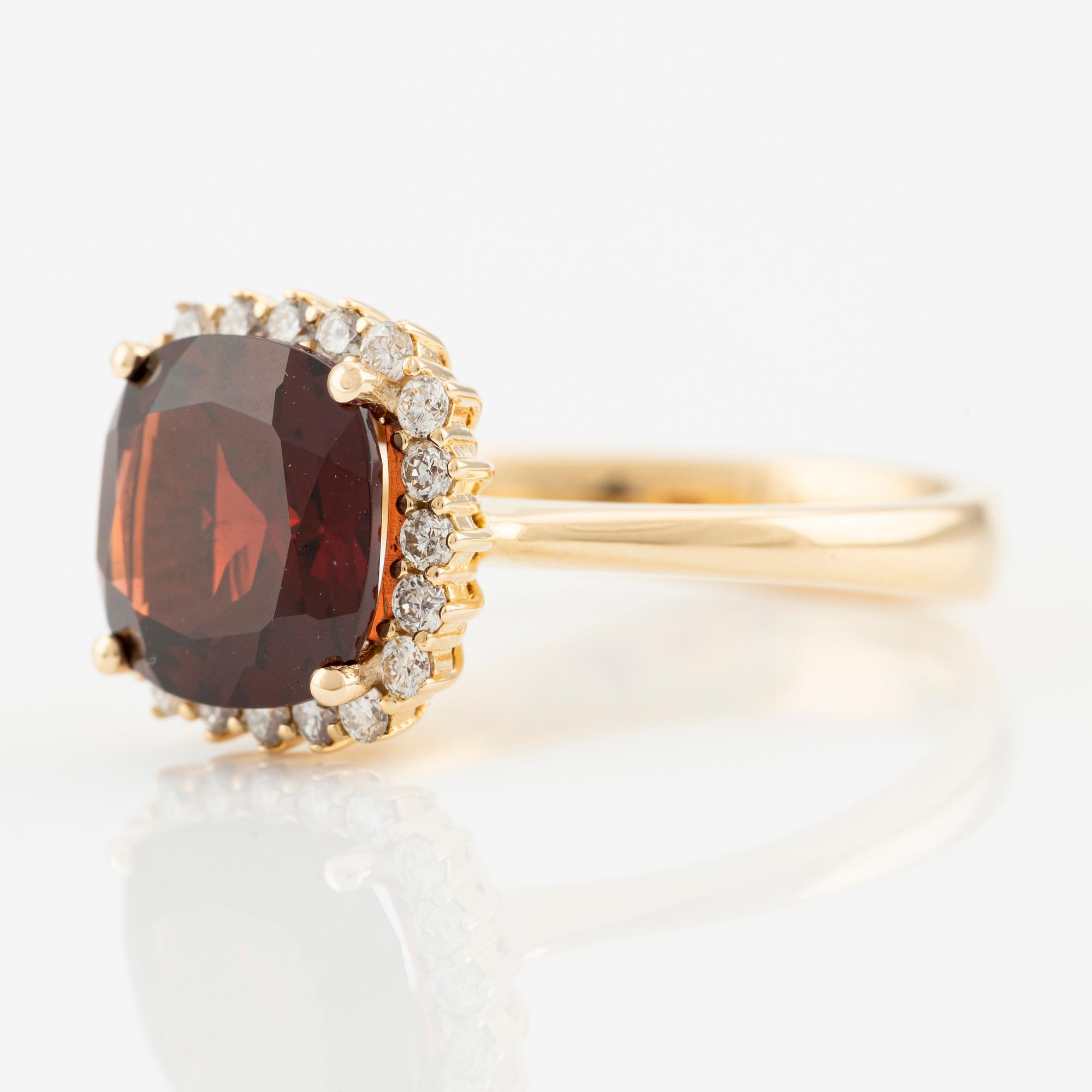 Ring in 18K gold with a faceted garnet and round brilliant-cut diamonds.