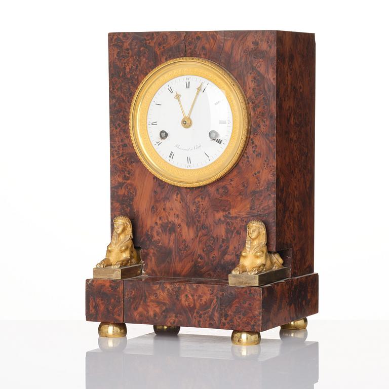 A French Empire burr-amboyna and ormolu mounted 'pendule borne' mantel clock by Barrand (master in Paris 1805-32).