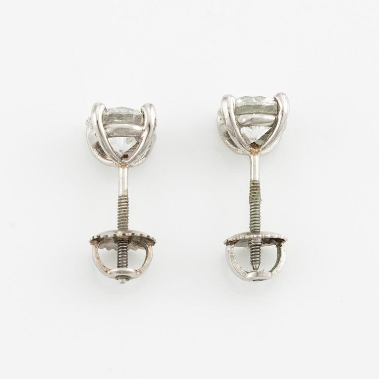 A pair of platinum earrings with round brilliant-cut diamonds.