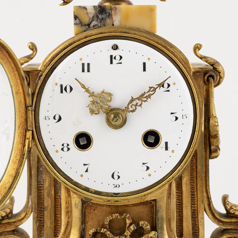A pair of candelabras and a mantel clock, Louis XVI-style, circa 1900.