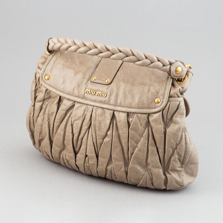 Miu Miu, a light leather handbag.