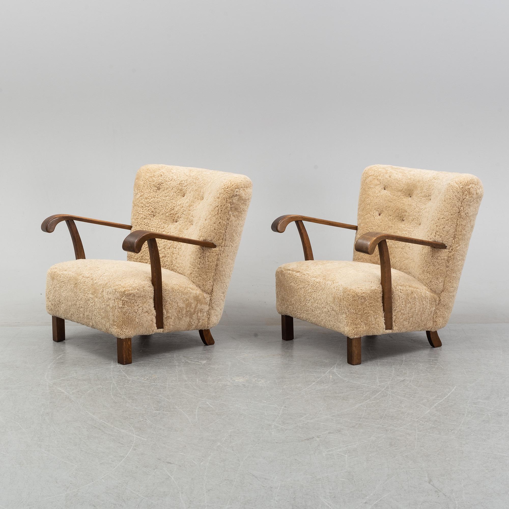 A pair of Danish lounge chairs with sheepskin upholstery.