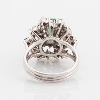 Ring platina med en fasettslipad smaragd och runda briljantslipade diamanter.