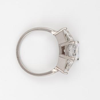A radiant-cut diamond 3.01 cts ring. Flanked by two triangular cut diamonds, 0.50 ct each. E/VS2, certificate from HRD.