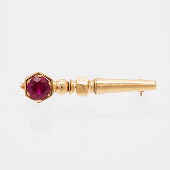 An 18K gold brooch set with a synthetic ruby.