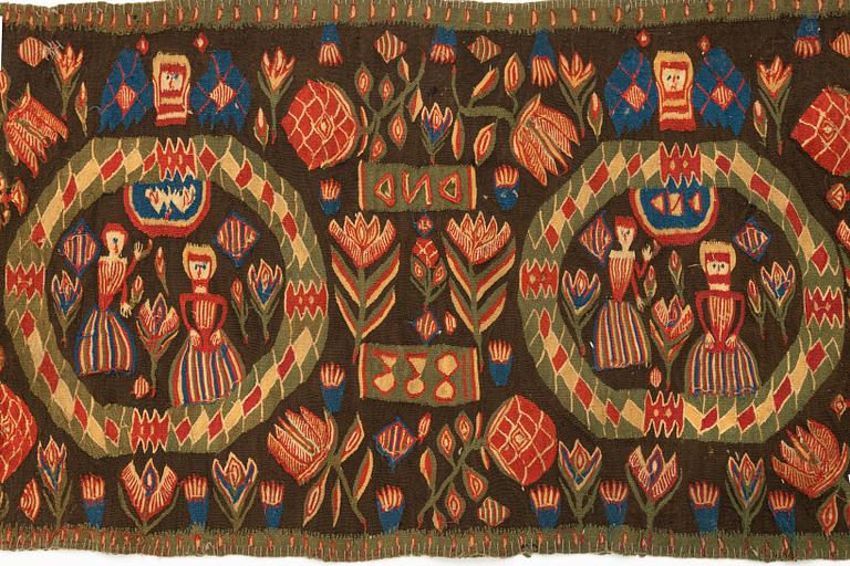 A carriage cushion, "the Annunciation", tapestry weave, ca 103 x 51 cm, south western Scania (Sweden), 1833.