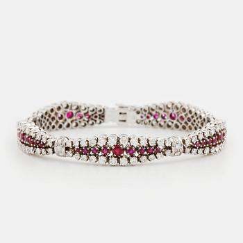 An 18K white gold bracelet set with rubies and round brilliant-cut diamonds.