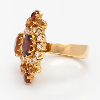 An 18K gold ring "Sophia Albertina", garnets, citrines, diamonds ca. 0.54 ct in total. Ofelia Jewelry, Helsinki 1998.