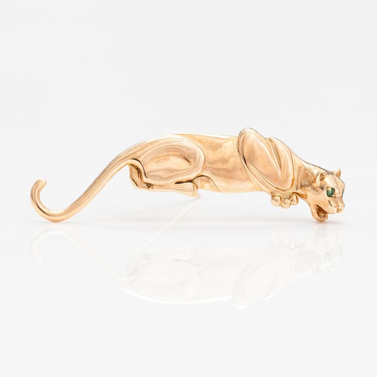 A panther brooch made of 14K gold and with emeralds.