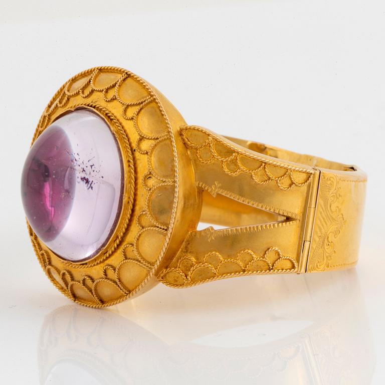 An 18K gold bracelet set with a cabochon-cut amethyst.