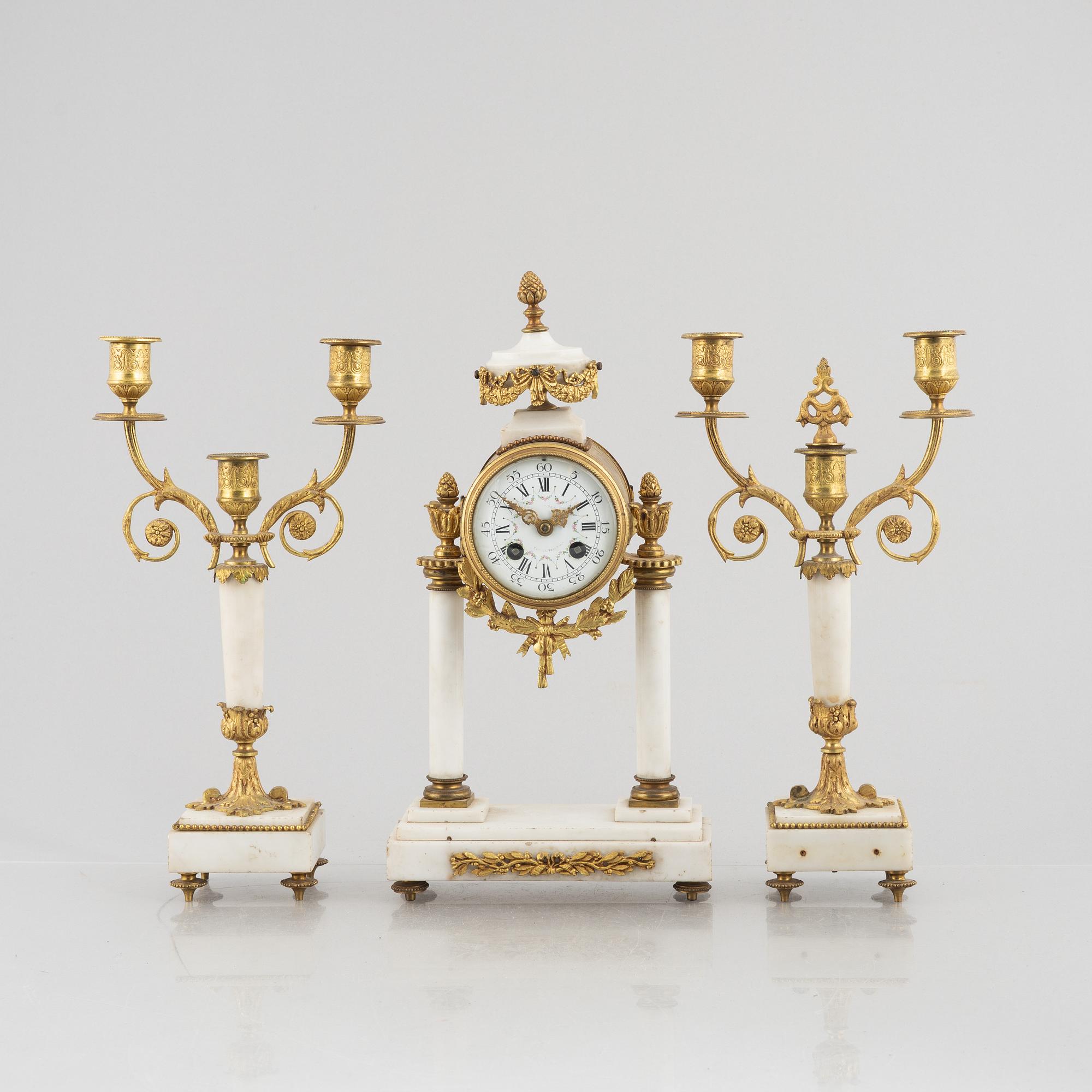 A Louis XVI-style mantel clock Paris, France and a pair of candelabras, late 19th century.