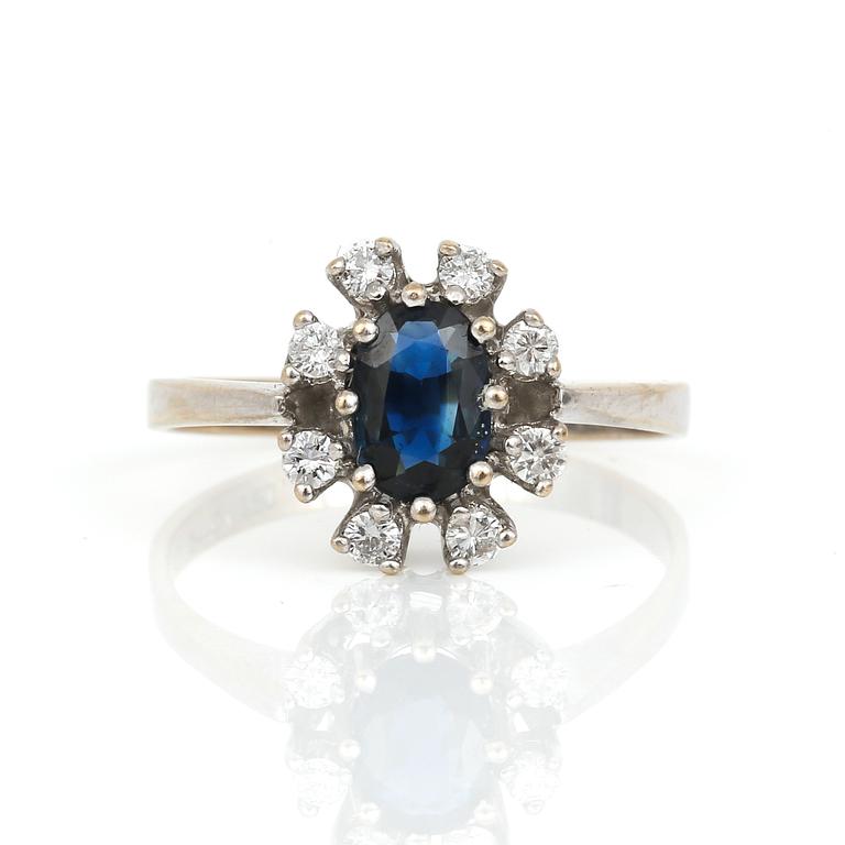 RING, 18K vitguld med ovalslipad safir ca 0,29 ct och briljantslipade diamanter tot ca 0.20 ct. Vikt ca 3,25 g.