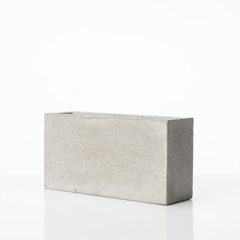 Stina Lindholm, a contemporary concrete planter 'Spira', a concrete flower pot and a wall clock.