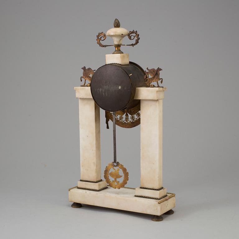 A FRENCH EMPIRE MARBLE AND BRASS MANTEL CLOCK, first half of the 19th century.