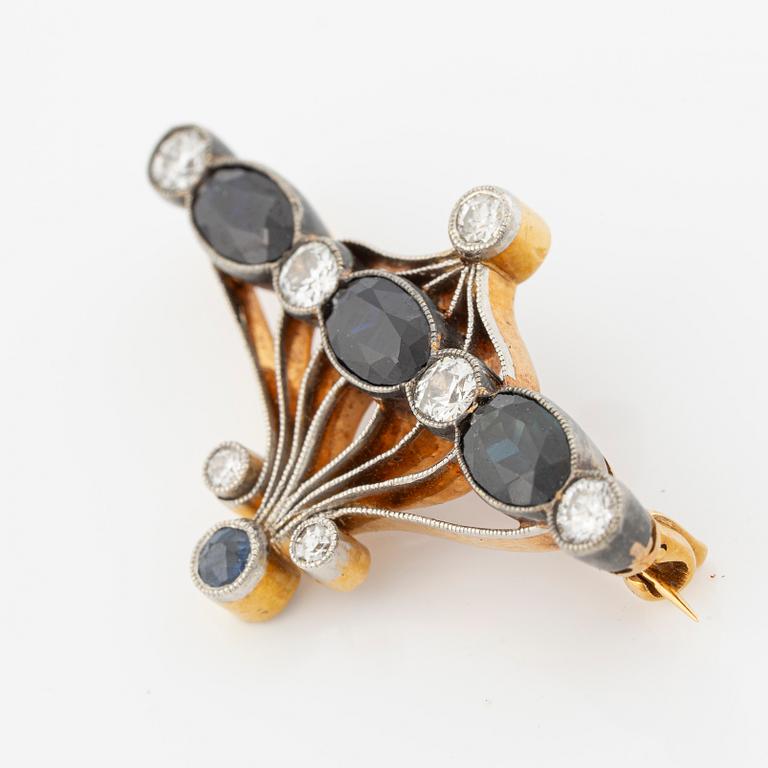 Brooch 18K gold and platinum set with step-cut sapphires and round brilliant-cut diamonds.