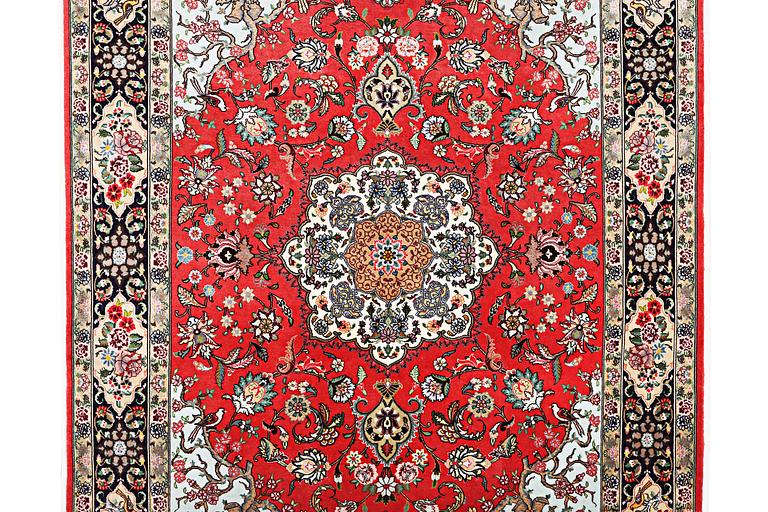 A figural Tabriz rug, part silk, 50 raj, signed, c. 202 x 152 cm.