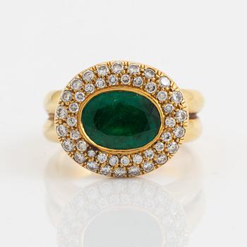 Oval emerald and brilliant cut diamond cluster ring.