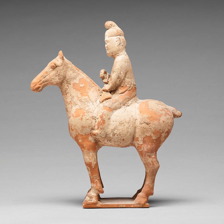 A painted pottery figure of an equestrian standard-bearer, Tang dynasty (618-907 AD.).